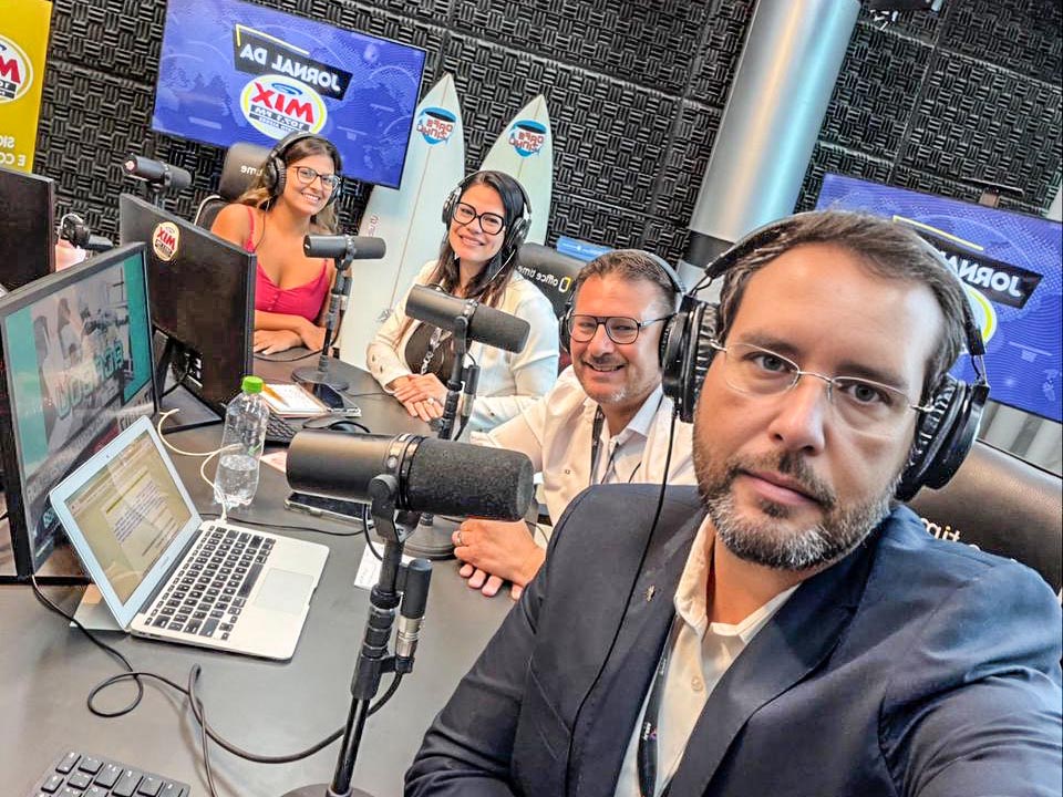 Ruy Irigaray no estúdio da Rádio MIX FM 107.1 da ULBRA, com equipe e alunos em gravação