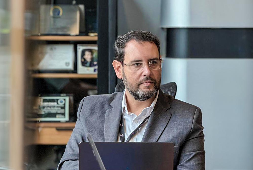 Ruy Irigaray no estúdio da Rádio MIX FM 107.1 da ULBRA com equipe e alunos, destacando inovação e prática acadêmica